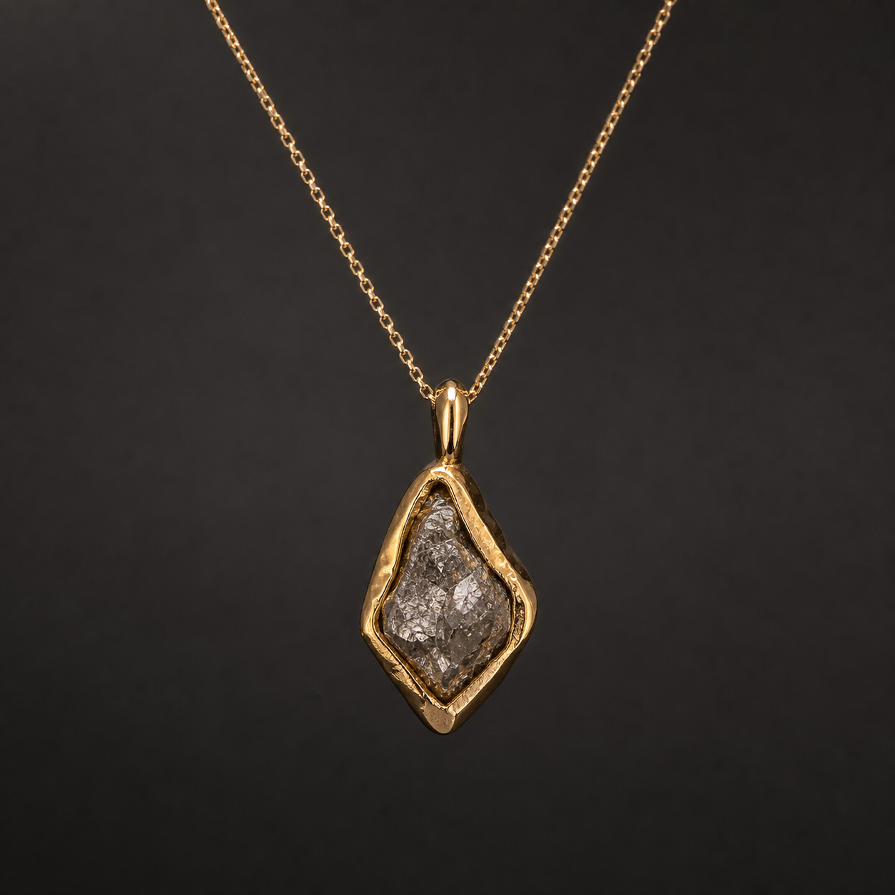 Photograph of a gold pendant necklace with a rough diamond